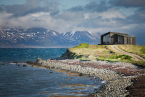 Red house next to a fjord in north Iceland.